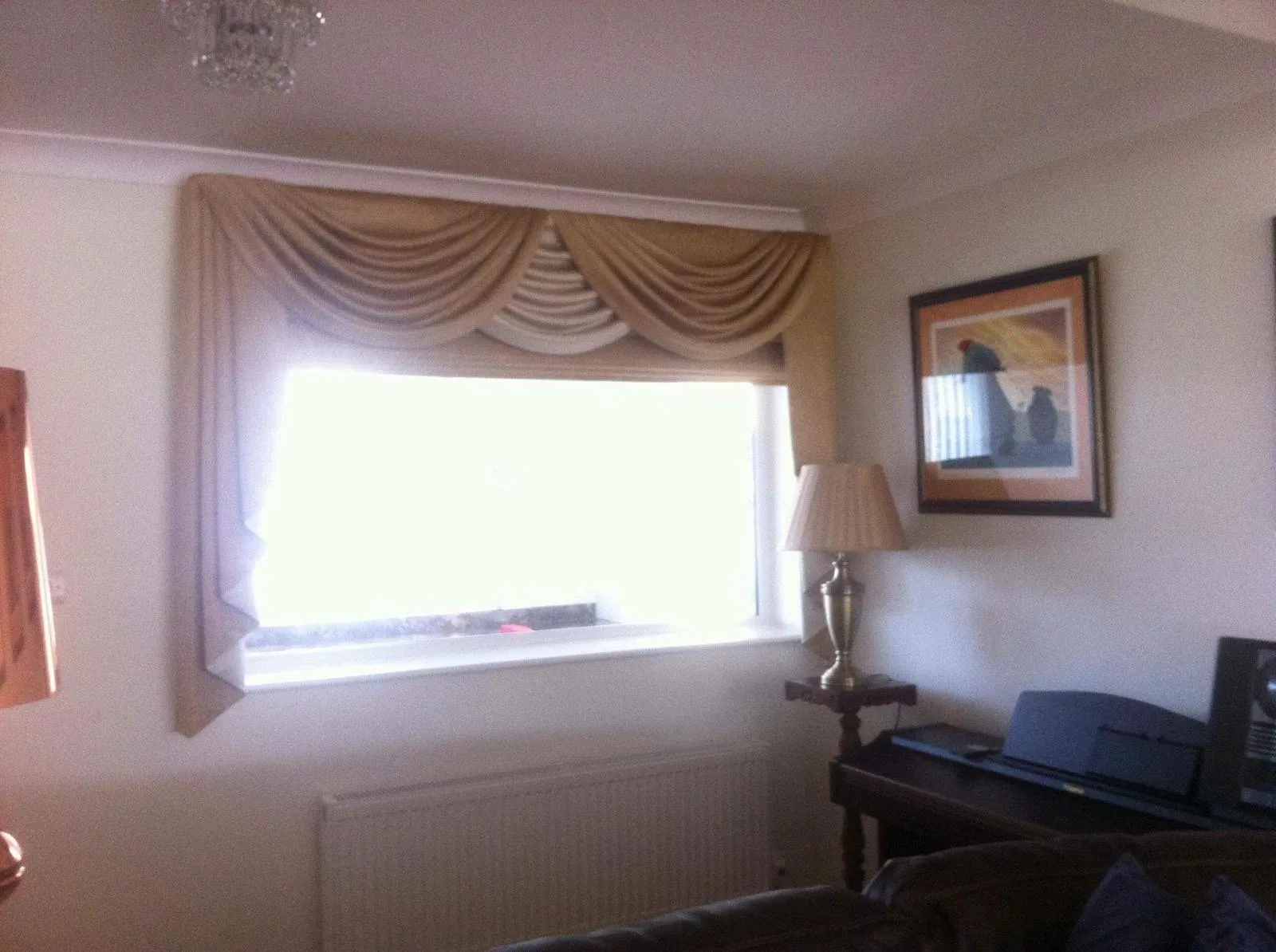 Draped swag and tails in cream and gold over a living room window