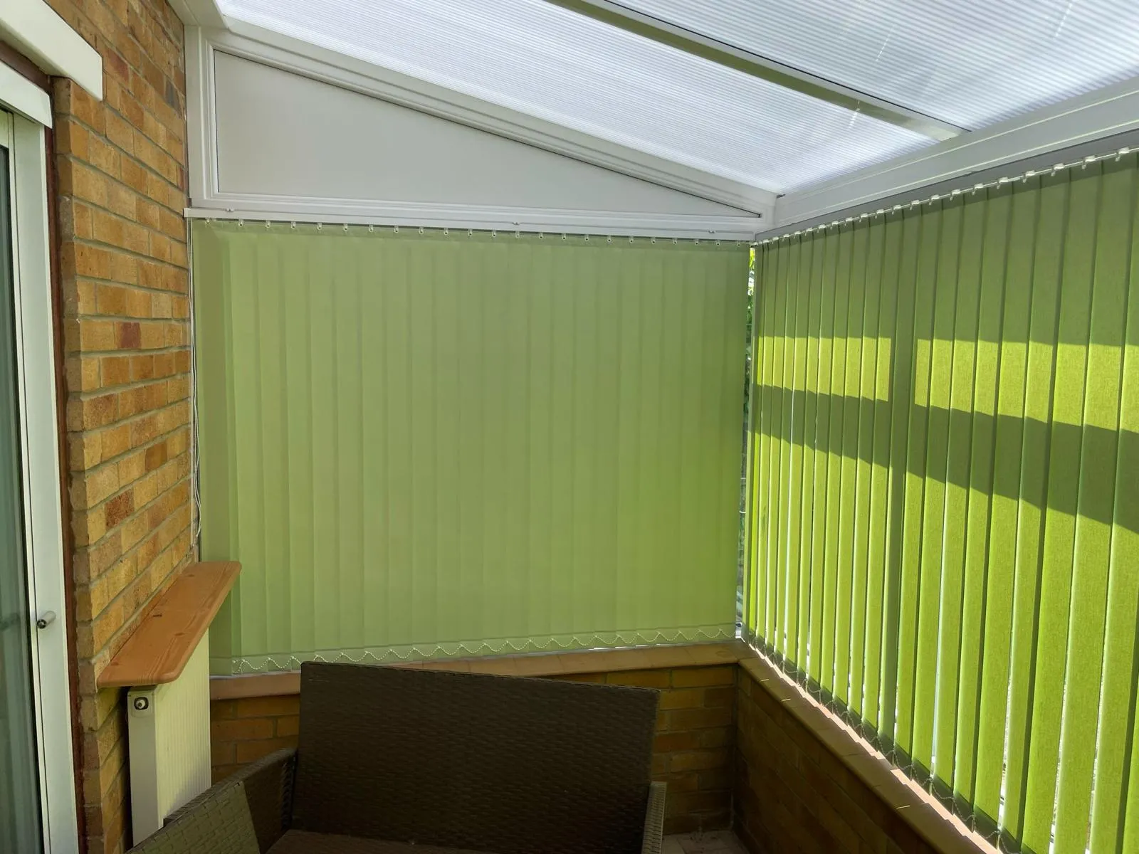 Lime green vertical blinds along the windows of a sunlit conservatory